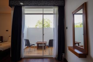 a room with a sliding glass door with a table and chairs at CROWN REGENCY- BADULLA in Badulla