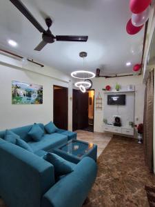 a living room with blue couches and a tv at AM Living in Ghaziabad +13 photos