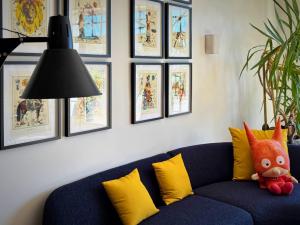 a blue couch in a living room with pictures on the wall at Gabriel Hotel Chinon in Chinon