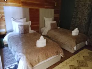 a bedroom with two beds with white towels on them at Chalets tourtite ifrane in Ifrane