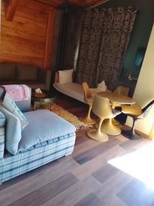 a living room with a couch and a table and chairs at Chalets tourtite ifrane in Ifrane