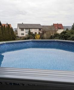a large blue swimming pool on top of a house at Schöne Wohnung mit Whirlpool und Sauna in Gontershausen