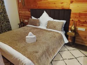 a bedroom with a large bed with a black headboard at Chalets tourtite ifrane in Ifrane