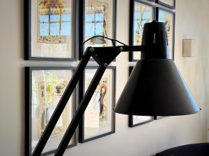 a black lamp in a room with pictures on the wall at Gabriel Hotel Chinon in Chinon