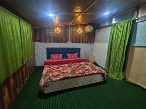 a bedroom with a bed with red pillows and green curtains at Shamus Javed Homestay in Srinagar +48 photos