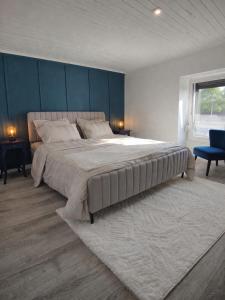 a bedroom with a large bed with a blue wall at Maison 8p 4ch A31 Recharge electrique in Rolampont