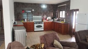 a kitchen with wooden cabinets and a white stove top oven at منزل ومزرعه للايجار الشوبكً Farm for rent , Shoubak , Petra in Nijil