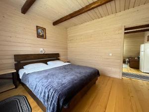 a bedroom with a bed in a wooden wall at Наш котедж in Krivopolʼye