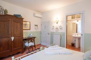 a bedroom with a bed and a desk and a sink at Il Nido Di Anna in San Gimignano +55 photos