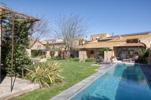 a backyard with a swimming pool and a house at Les Hamaques hotel in Viladamat