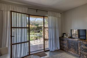 a living room with a tv and a sliding glass door at Les Hamaques hotel in Viladamat