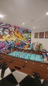 a room with a pool table and a mural at Maison 8p 4ch A31 Recharge electrique in Rolampont