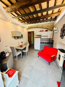 a living room with a red couch and a table at Il Nido della Regina - 250m dal Lago di Bolsena in Marta