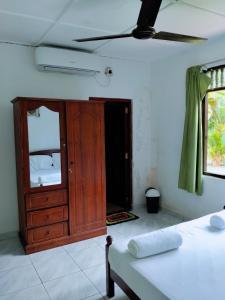 a bedroom with a wooden cabinet and a bed at New Villa Senor Beruwala in Beruwala +27 photos