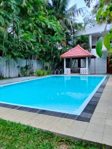 a swimming pool in a backyard with a gazebo at New Villa Senor Beruwala in Beruwala
