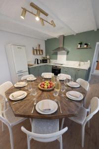 a kitchen with a wooden table with a bowl of fruit on it at Maison 8p 4ch A31 Recharge electrique in Rolampont +13 photos