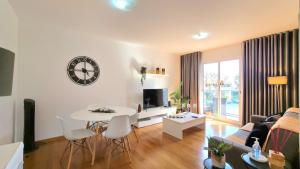 a living room with a table and a clock on the wall at Casa Silvana in Caniço