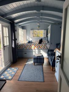 a bedroom with a bed and a couch in it at Bluebell Shepherd's Hut in Llanfair