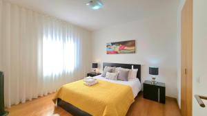 a bedroom with a large bed with a yellow blanket at Casa Silvana in Caniço
