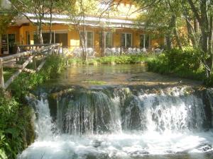 uma cascata em frente a uma casa em Hotel El Tablazo em Villalba de la Sierra