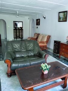 a living room with a leather couch and a coffee table at New Villa Senor Beruwala in Beruwala