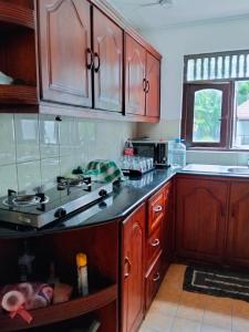 a kitchen with wooden cabinets and a stove top oven at New Villa Senor Beruwala in Beruwala