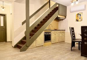 a kitchen with a staircase in the middle of a room at Къща за гости Арт Спектър in Bratsigovo
