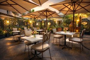 a restaurant with white tables and chairs and umbrellas at Hotel Diplomatic in Rome