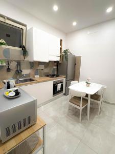 a kitchen with a table and a sink and a table and a kitchen with at Nicola's Apartments in Santa Maria La Carità +23 photos