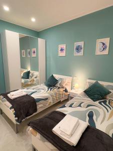 a bedroom with two beds and a mirror at Nicola's Apartments in Santa Maria La Carità