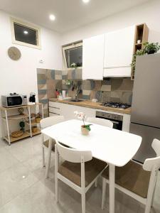 a kitchen with a white table and white chairs at Nicola's Apartments in Santa Maria La Carità