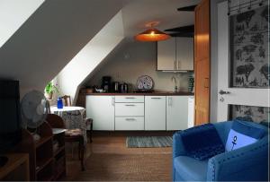 a kitchen and a living room with a blue couch at Cozy loft living in Malmö