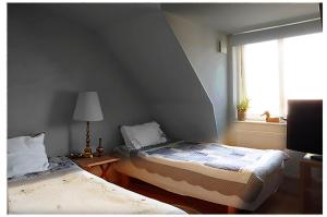 a bedroom with two beds and a window at Cozy loft living in Malmö