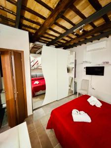 a bedroom with a red bed with two towels on it at Il Nido della Regina - 250m dal Lago di Bolsena in Marta