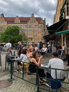 a group of people sitting at a table in a city at Cozy loft living in Malmö