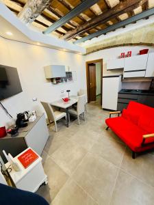 a living room with a red couch and a table at Il Nido della Regina - 250m dal Lago di Bolsena in Marta