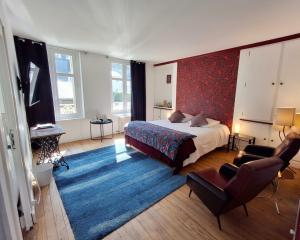 a bedroom with a bed and a blue rug at Le Huis Clos in Amboise