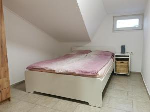 a white bedroom with a bed in a attic at apartma Jelka in Novigrad Istria
