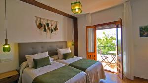 ein Schlafzimmer mit zwei Betten und Balkon in der Unterkunft Las Perdices in Válor