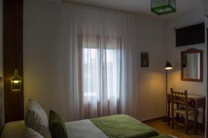 ein Schlafzimmer mit einem Bett und einem Fenster mit Vorhängen in der Unterkunft Las Perdices in Válor