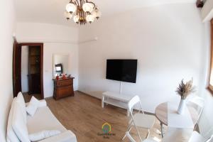 a living room with a table and a flat screen tv at Argent House Orbetello in Orbetello