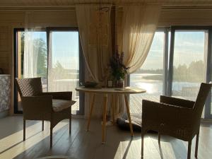 a table and chairs in a room with a large window at Ezermāja "Spārītes" in Geraņimova +16 photos