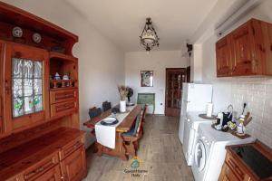 a kitchen with a table and a white refrigerator at Argent House Orbetello in Orbetello +5 photos
