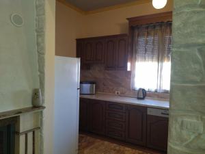 a kitchen with a white refrigerator and a window at The Garden Guest House in Divjakë