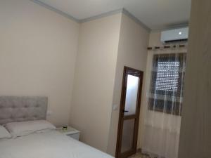 a small bedroom with a bed and a window at The Garden Guest House in Divjakë