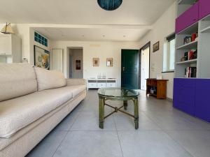 a living room with a couch and a glass table at Fortuna Garden House in Imperia +32 photos