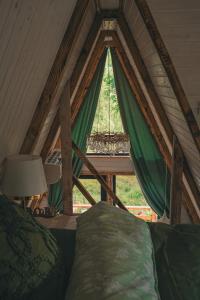 a room with a bed and a window in a tent at Acasa Straja - Treehouse in Lupeni