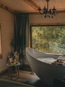 a bath tub in a room with a window at Acasa Straja - Treehouse in Lupeni +50 photos