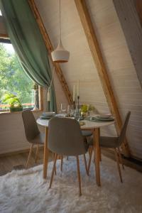 a dining room table with chairs in a attic at Acasa Straja - Treehouse in Lupeni