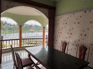 a dining room with a table and chairs and windows at Hotel Raj in mayapur